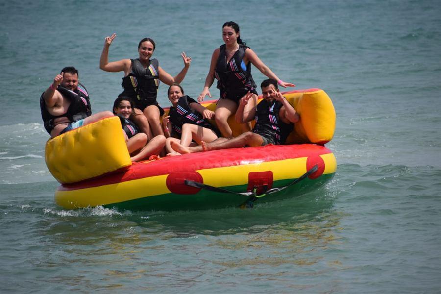 A group of six, arms up, on the ring off the beach
