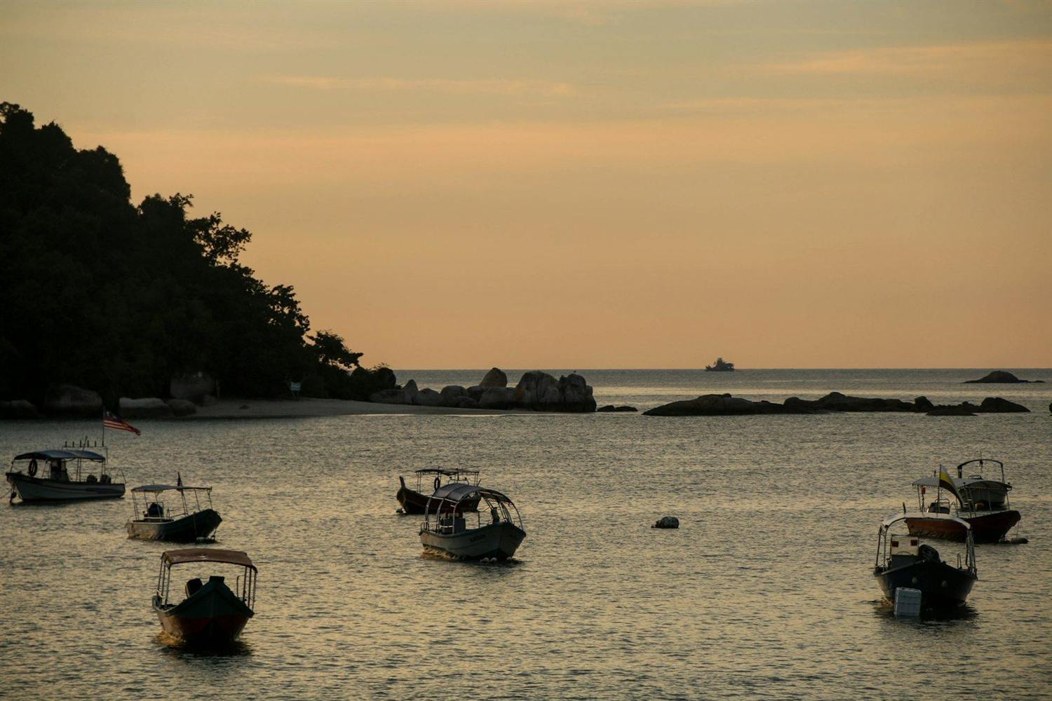 An orange sunset over the sea, seen from the deck of a boat