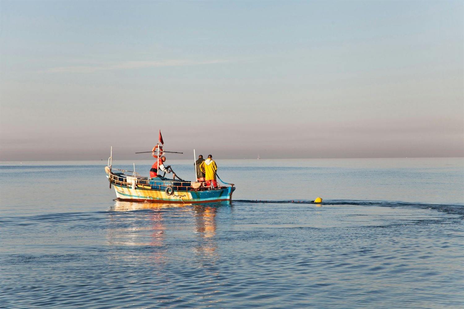 The team gathered at the stern of a boat at anchor